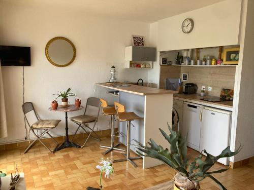 une cuisine avec un comptoir, une table et des chaises dans l'établissement BLEU SOLEIL - STUDIO 23 M2 - BALCON - PORT et PLAGES, à Canet