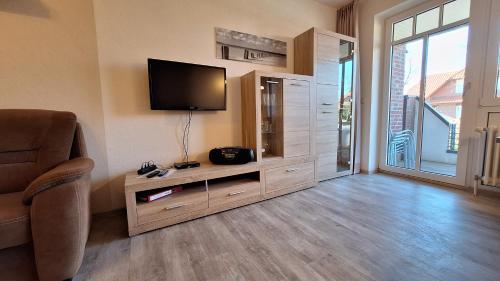 a living room with a flat screen tv on a wall at Ferienwohnung Boje 6 in Schillig