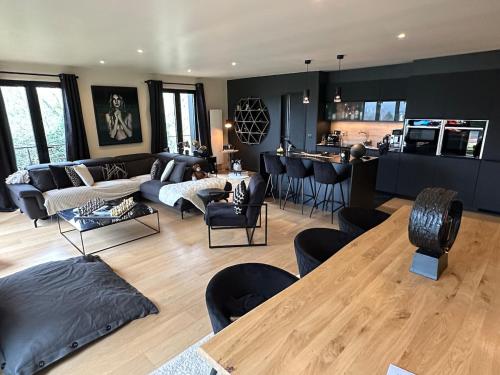 un ampio soggiorno con tavolo e sedie di B&W Maison tout confort Honfleur a Gonneville-sur-Honfleur