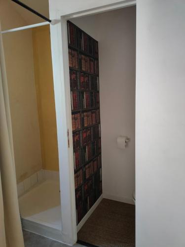 une étagère remplie de livres dans une pièce dans l'établissement Studio Romarin au pied des Arènes, à Arles