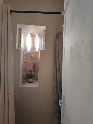 La salle de bains est pourvue d'une douche, d'une fenêtre et d'une porte. dans l'établissement Studio Romarin au pied des Arènes, à Arles