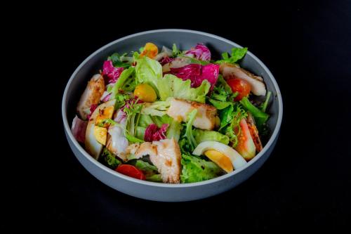 a salad in a bowl on a table at GRANFERTE Phnom Penh Hotel in Phnom Penh
