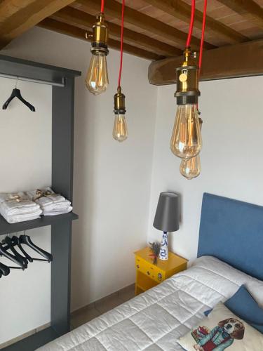 UsiglianoにあるLa casa giallaの天井から4つのライトがぶら下がっている寝室