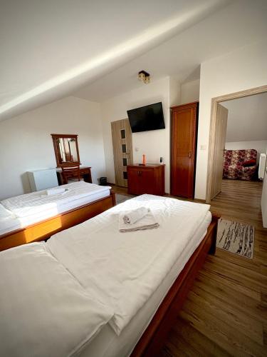 a hotel room with two beds and a flat screen tv at Penzion Urban in Havířov