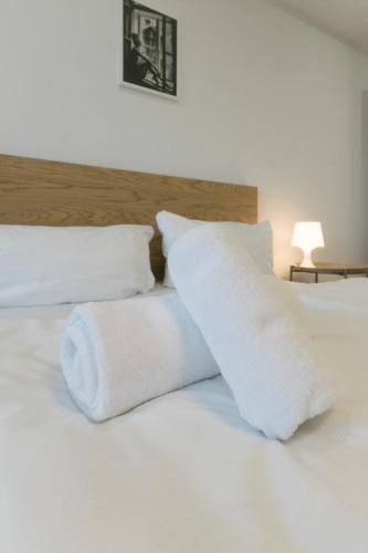 a bed with white sheets and pillows on it at NEUES Apartment in Top Lage, free Parking max 1,65m Höhe und 1,8m Breite in Karlsruhe
