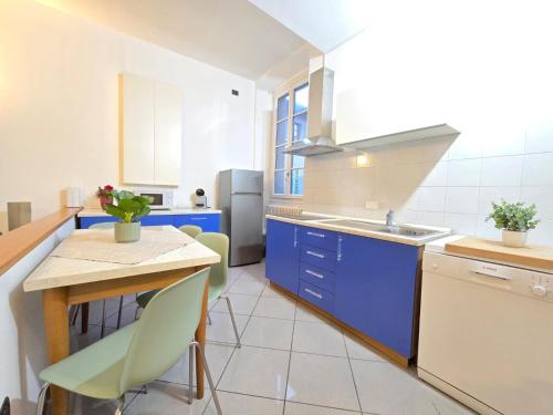 a kitchen with blue cabinets and a table with chairs at Russomanno Apartments 6 in Como