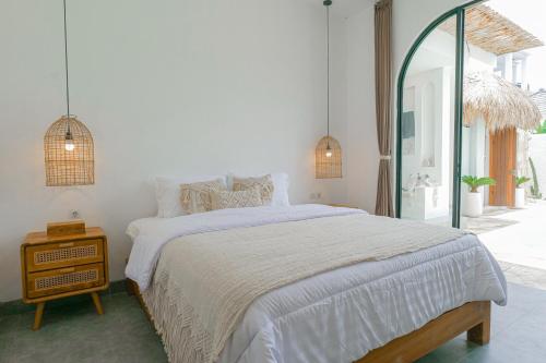 Un dormitorio blanco con una cama y un espejo. en Villa PJ Ungasan, en Uluwatu