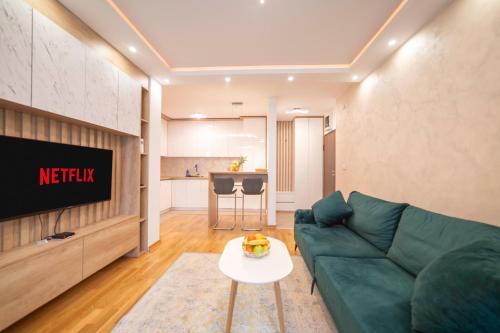 a living room with a green couch and a table at Apartment 5 Star - Free Parking in Lukavica