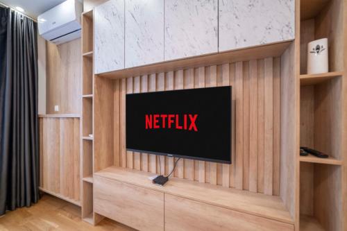 a tv on a wall with a netflix sign on it at Apartment 5 Star - Free Parking in Lukavica