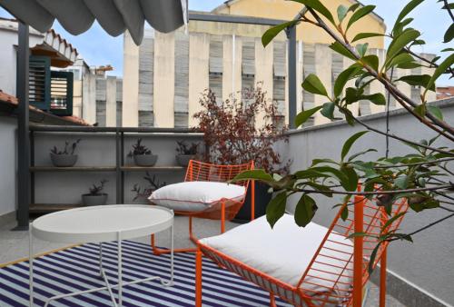 a patio with two chairs and a table on a balcony at MILIN DOM Premium Apartments in Split