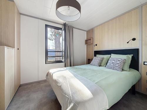 a bedroom with a large bed and a window at La Criste Marine in Jullouville-les-Pins