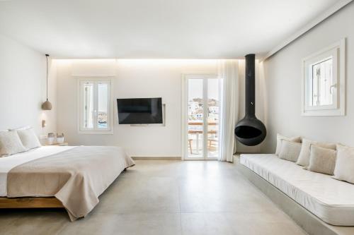 a white bedroom with a bed and a couch at Kythnos Blue - Suite 4 Luxurious, Sea Front in Kithnos