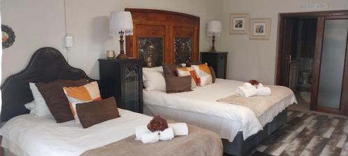 two beds in a hotel room with towels on them at VetraAmour Guesthouse 2 in Kimberley