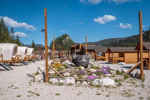 a garden with a statue of a bear in a yard at Tiny House - Ranč Ľadová - Zážitkové ubytovanie in Stratená