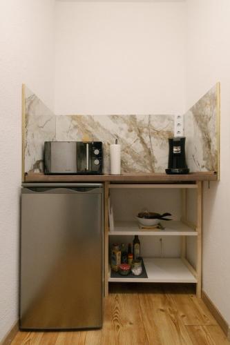 a kitchen with a refrigerator and a shelf with a microwave at NEUES Apartment in Top Lage, free Parking max 1,65m Höhe und 1,8m Breite in Karlsruhe