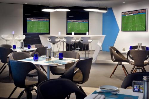 a conference room with tables and chairs and televisions at Southern Sun Abu Dhabi in Abu Dhabi