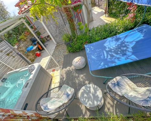 a patio with a table and chairs next to a swimming pool at Beachfront House with Private Jacuzzi and Garden Zadar in Zadar