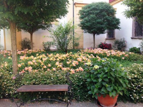 a bench sitting in a garden with flowers at Zámek Jemniště in Postupice