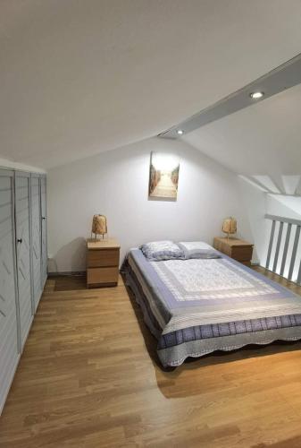 una camera da letto con un letto grande e due comodini di Bel appartement face Océan a Soulac-sur-Mer