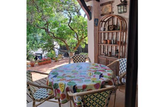 une table et des chaises sur une terrasse avec une table dans l'établissement Agréable maison au Pyla sur mer 6 personnes, à La Teste-de-Buch