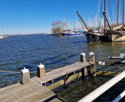 a wooden dock with a boat in the water at Bed & Breakfast De Punt in Monnickendam