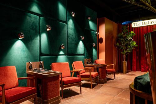 a waiting room with red chairs and a green wall at The Ostendian in Ostend
