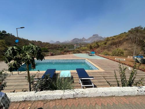 a swimming pool with two lounge chairs next to it at ILA Villa in Vajapūr