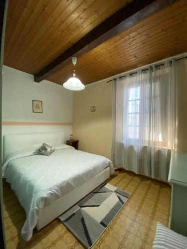 a bedroom with a white bed and a window at Pierina in Lucca