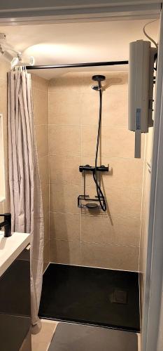 La salle de bains est pourvue d'une douche avec un tabouret. dans l'établissement Gîte Le Bosquet, à Mariac