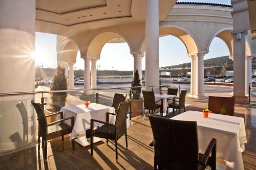 a restaurant with tables and chairs on a balcony at Casino & Hotel ADMIRAL Kozina in Kozina