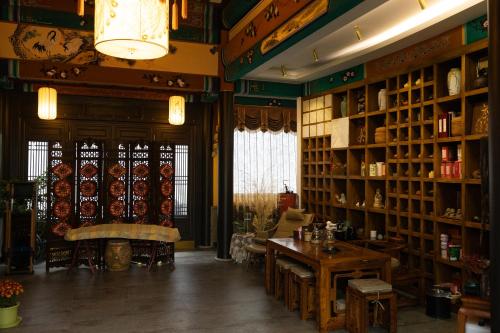 a room with a table and shelves of dishes at Datong Yunzhong Traditional Courtyard in Datong