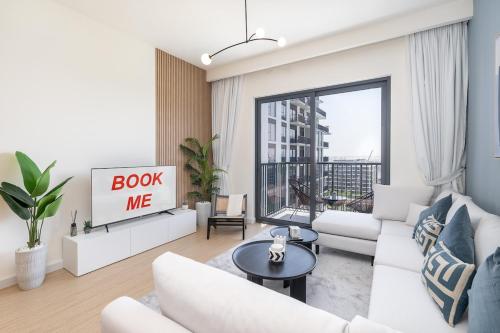 a living room with a white couch and a tv at Free housekeeping visits during your stay - StayShort - Chic 1-Bed for 4 in Prime Dubai Hills Location in Dubai