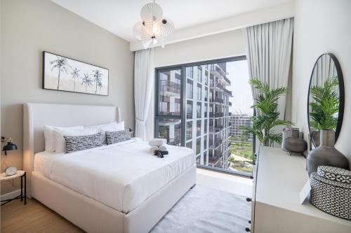 a white bedroom with a bed and a large window at Free housekeeping visits during your stay - StayShort - Chic 1-Bed for 4 in Prime Dubai Hills Location in Dubai