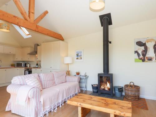a living room with a couch and a fireplace at The Shippon at Wyke Farm in Axminster
