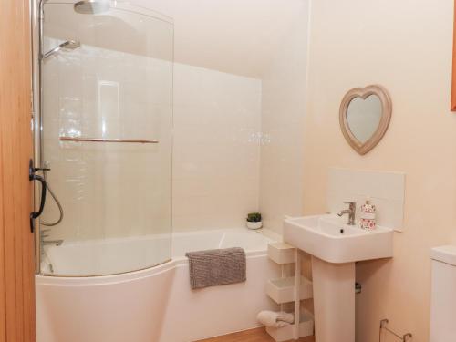 a bathroom with a tub and a sink and a shower at The Shippon at Wyke Farm in Axminster