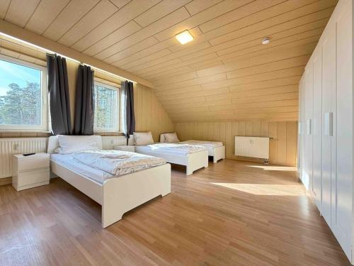 two beds in a large room with wooden ceilings at WA1002 Geräumige Monteurwohnung Übergangswohnung in Wackersdorf