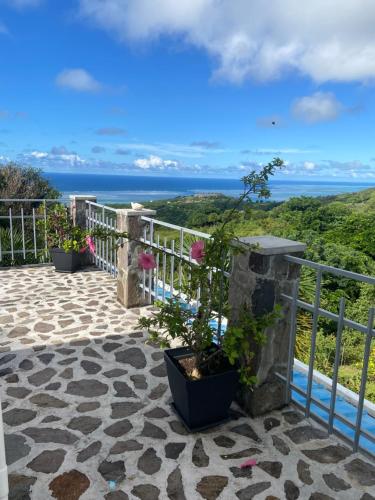 a balcony with a view of the ocean at Charming Villas in Rodrigue in Tambe