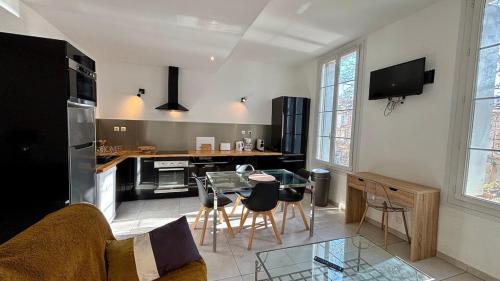 un salon avec une table et une cuisine dans l'établissement Charmant 3 pièces au coeur du vieux Montpellier, à Montpellier