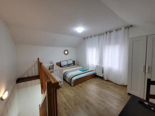 a small bedroom with a bed and a staircase at Duplex apartment 700 m from Compiègne train station in Margny-lès-Compiègne