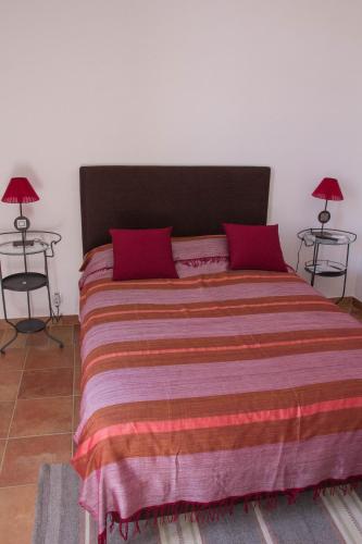a bedroom with a large bed with red pillows at Casas da Moagem in São Domingos