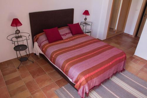 a bedroom with a large bed with two lamps at Casas da Moagem in São Domingos