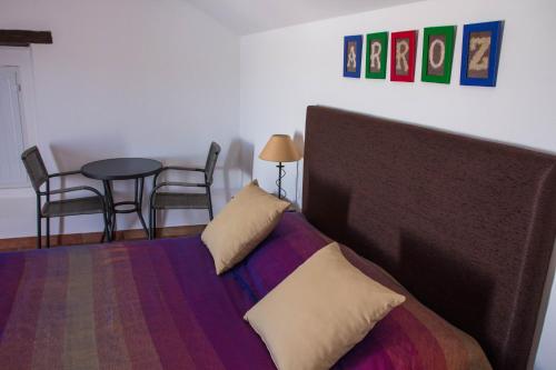 a bedroom with a bed and a table with chairs at Casas da Moagem in São Domingos