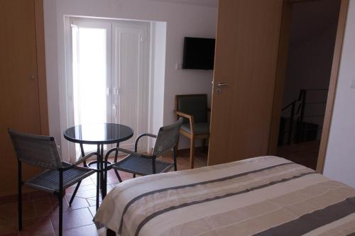 a room with a table and chairs and a bed at Casas da Moagem in São Domingos
