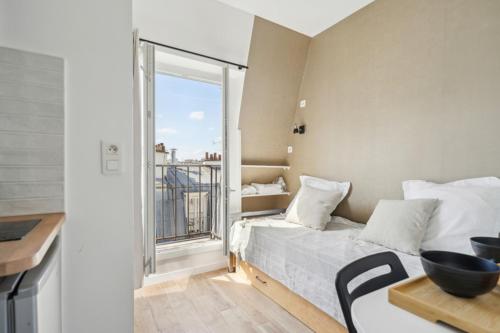 une chambre avec un lit, une table et une fenêtre dans l'établissement 505 Suite Mozart 2 - Cosy studio in Paris 16th, à Paris