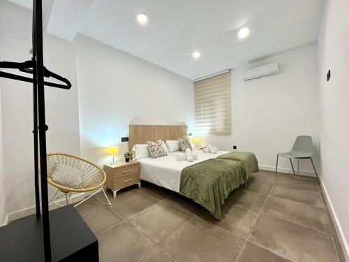 a bedroom with a bed and a chair in it at New Víctor Villegas Auditorium y FICA AP2 in Murcia