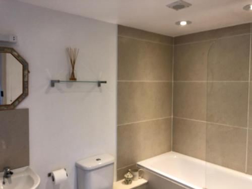 a bathroom with a tub and a toilet and a sink at Cocklekitty Cottage in Kelso