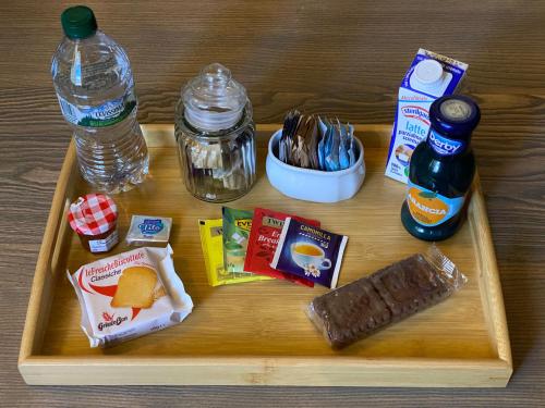 a tray with food and a drink and a bottle of water at Le Antiche Mura 2 in Guastalla