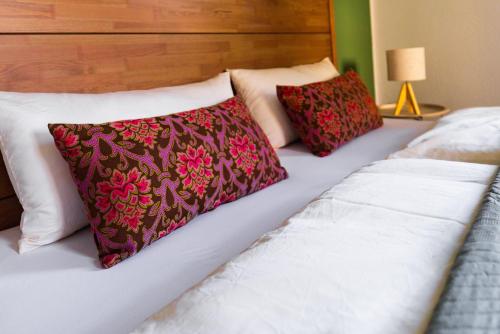 a bed with three pillows on top of it at HohnsteinOase-Fasssauna und Kühlbecken-3 SZ-Parkplatz - Waschmaschine in Hohnstein