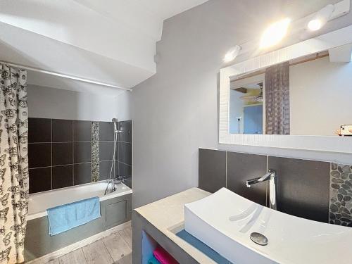 une salle de bain avec un lavabo, une baignoire et un miroir dans l'établissement Canolle Charme Climatisé 1mn du port by LaConciergerie13, à La Ciotat