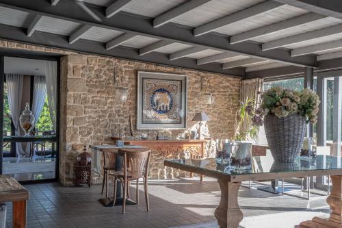 a living room with tables and a stone wall at El Racó de Madremanya - Adults only in Madremanya